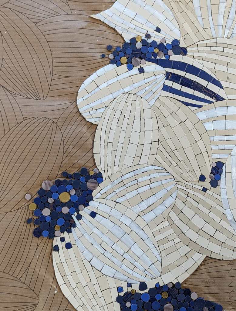 Oeuvre de mosaïque en cours avec tesselles de mosaïques bleues et blanches
